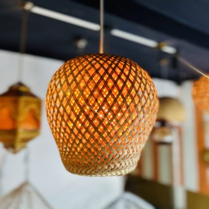 Inspired by the warmth of nature and the intricacy of traditional weaving, the Golden Nest Bamboo Pendant Light brings timeless beauty to modern interiors. Its round, globe-shaped silhouette is handwoven from natural bamboo in a crisscross lattice pattern, diffusing a soft, golden glow that transforms any space into a cozy haven. Perfect for ambient lighting in dining areas, reading nooks, cafes, or entryways, this artisan-made fixture seamlessly blends rustic charm with minimal elegance. Lightweight yet durable, it's a sustainable lighting solution that reflects conscious craftsmanship.