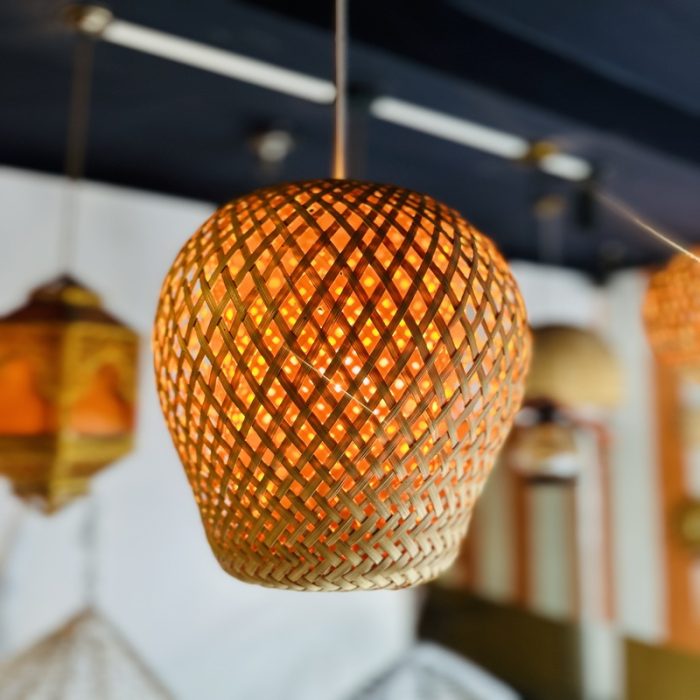 Inspired by the warmth of nature and the intricacy of traditional weaving, the Golden Nest Bamboo Pendant Light brings timeless beauty to modern interiors. Its round, globe-shaped silhouette is handwoven from natural bamboo in a crisscross lattice pattern, diffusing a soft, golden glow that transforms any space into a cozy haven. Perfect for ambient lighting in dining areas, reading nooks, cafes, or entryways, this artisan-made fixture seamlessly blends rustic charm with minimal elegance. Lightweight yet durable, it's a sustainable lighting solution that reflects conscious craftsmanship.