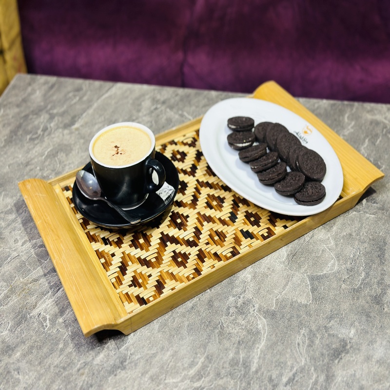Bring natural elegance to your table with our Handcrafted Bamboo Woven Serving Tray, beautifully made by skilled artisans. Featuring an eye-catching geometric tribal pattern, this tray is crafted from eco-friendly bamboo and rattan, making it a sustainable yet stylish choice for your home. Whether you're serving tea, snacks, or simply using it as a decorative piece, this tray adds a touch of rustic charm to any setting. The sturdy wooden frame and finely woven center combine beauty with durability, perfect for everyday use or special occasions.
